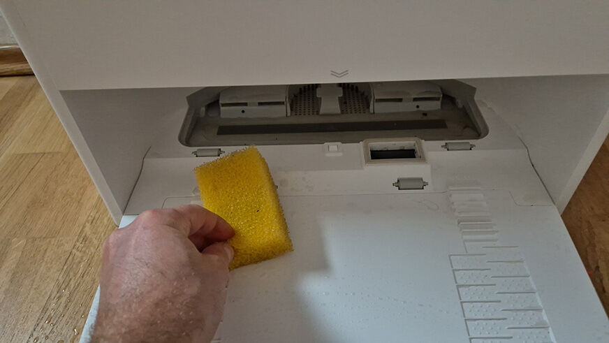 Die Dreame Aqua10 Roller Station wird mit einem Schwamm gesäubert.